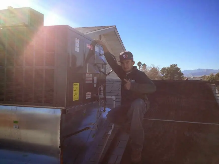 HVAC technician performing AC Tune-Up on a rooftop unit in West Frankfort